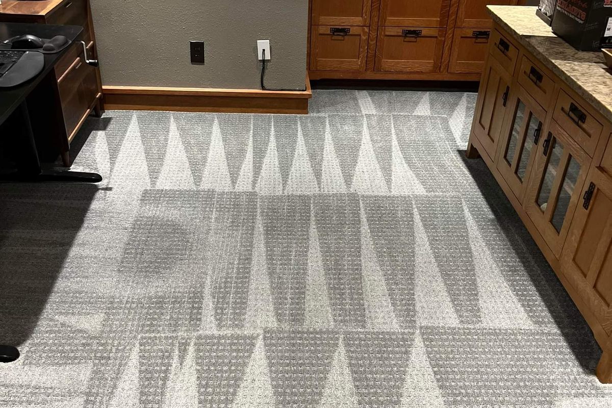 Office carpet partway through cleaning, cleaned sections beside traffic-worn carpet