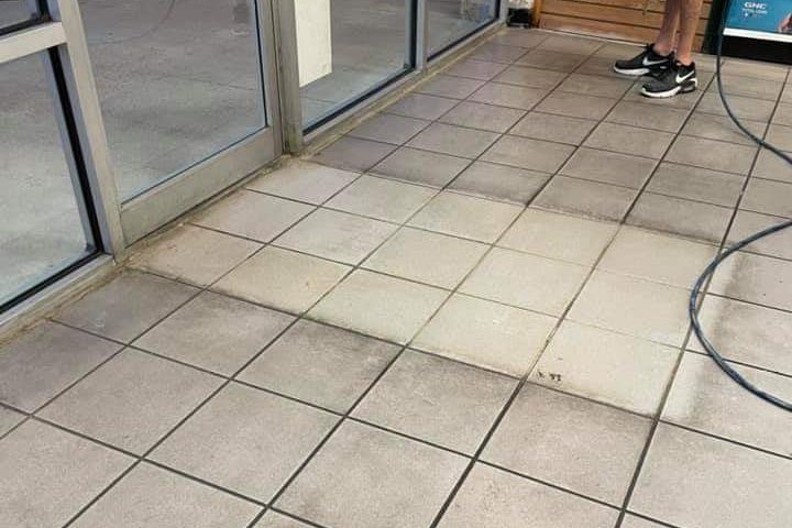 Storefront entry tile mid-cleaning, cleaned tile beside dirty grout